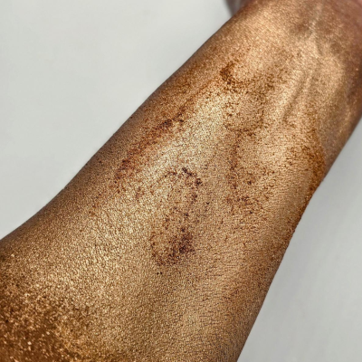 TobaGLOW Highlighter Swatch. A pearlized bronze powder that delivers an intense bronze glow on all complexions.